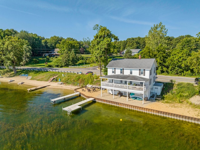 rear view of house with a water view and a balcony