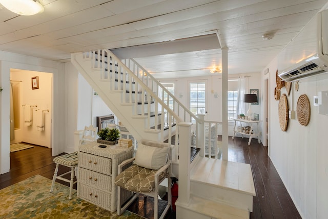 staircase featuring hardwood / wood-style floors, cooling unit, and an AC wall unit