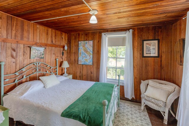 bedroom featuring wooden walls and wood ceiling