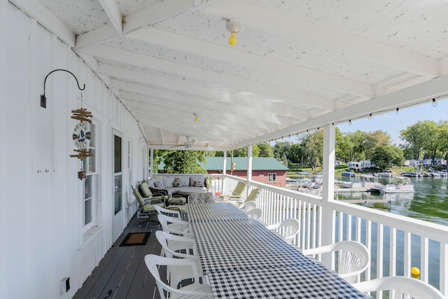 wooden terrace with ceiling fan and a water view