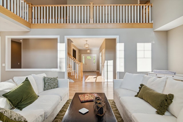 living area featuring stairs, a high ceiling, and wood finished floors