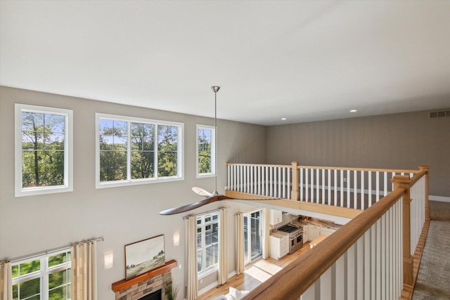 corridor featuring recessed lighting, visible vents, a high ceiling, an upstairs landing, and baseboards