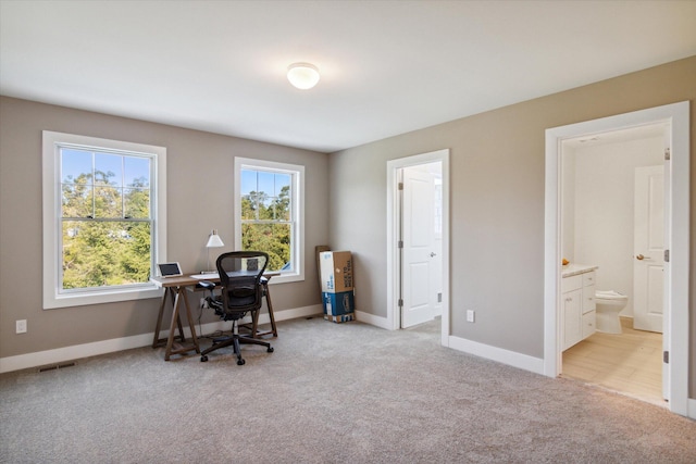 home office with light carpet, visible vents, and baseboards