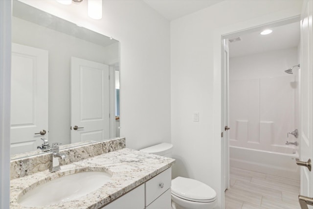 bathroom featuring visible vents, washtub / shower combination, vanity, and toilet