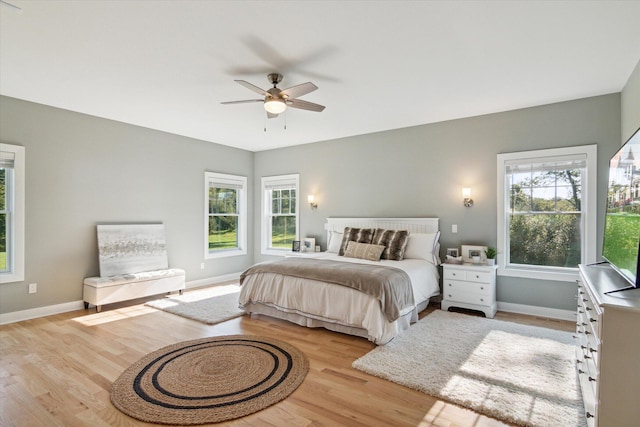 bedroom featuring ceiling fan, light wood-style flooring, and baseboards