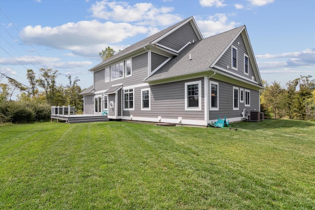 back of property featuring roof with shingles, central AC unit, a deck, and a yard