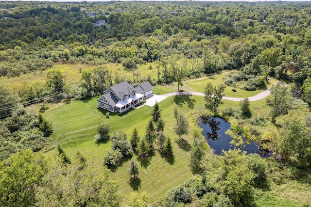 birds eye view of property with a water view and a view of trees