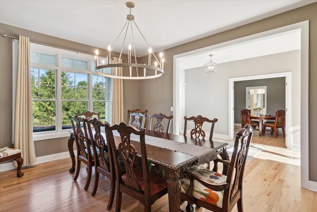 dining space with light wood-type flooring and baseboards