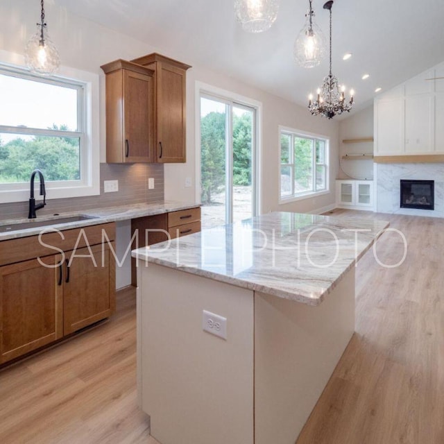 kitchen featuring sink, a center island, hanging light fixtures, lofted ceiling, and decorative backsplash