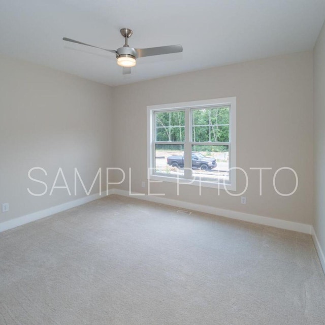 carpeted spare room featuring ceiling fan