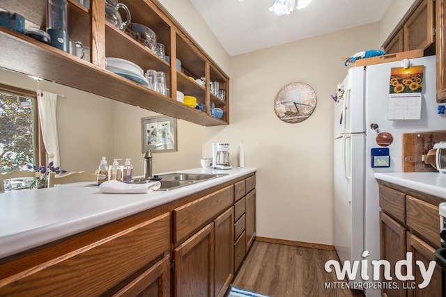kitchen with dark hardwood / wood-style floors, white refrigerator, and sink