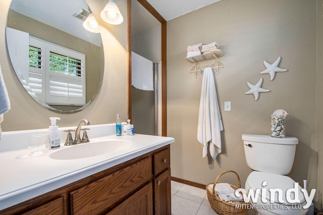 bathroom with tile patterned flooring, vanity, and toilet