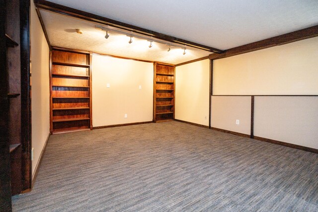 carpeted spare room featuring a textured ceiling, track lighting, and crown molding