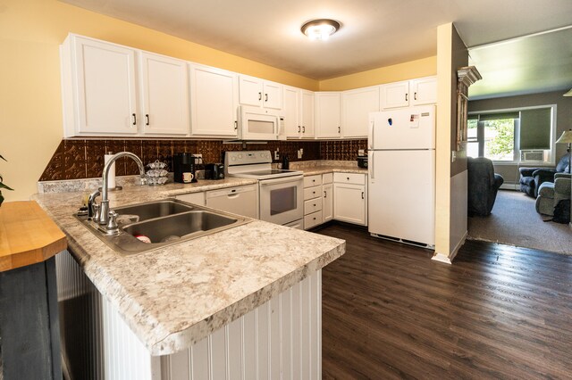 kitchen with kitchen peninsula, decorative backsplash, white appliances, sink, and white cabinets