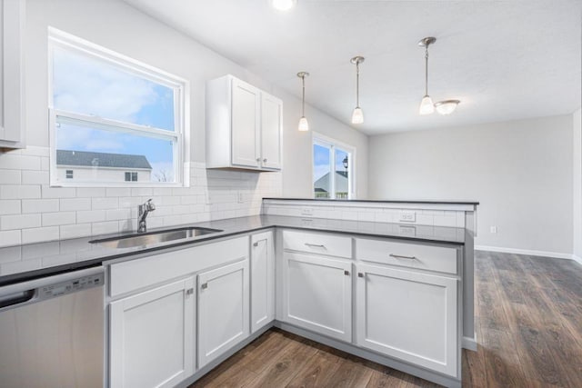 kitchen featuring pendant lighting, dishwasher, dark wood-type flooring, kitchen peninsula, and white cabinetry