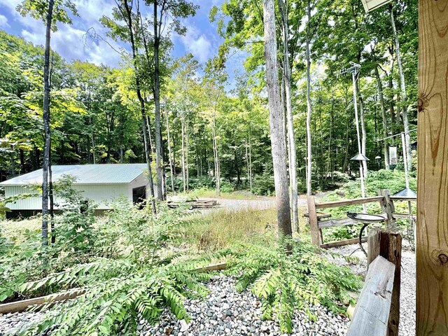 2144 N Jacobson Rd, Suttons Bay, MI 49682 - rear view of house featuring a patio, a fire pit, and roof with shingles