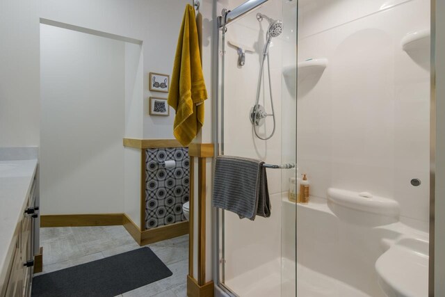 2144 N Jacobson Rd, Suttons Bay, MI 49682 - full bath with toilet, a stall shower, vanity, and baseboards