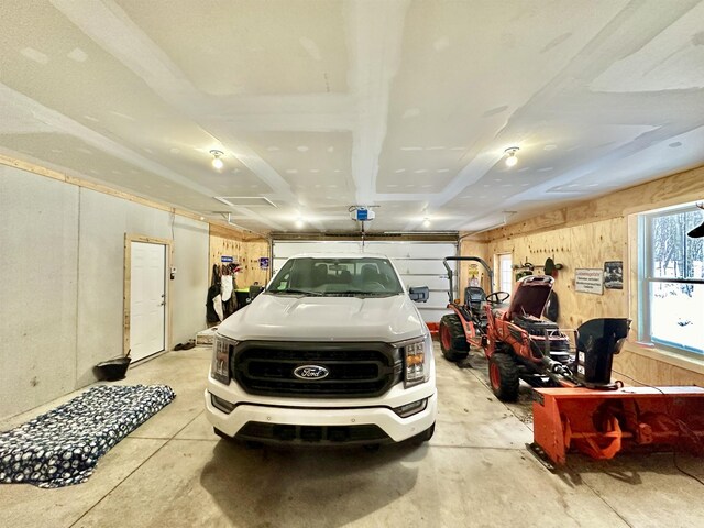 2144 N Jacobson Rd, Suttons Bay, MI 49682 - garage featuring a garage door opener and wood walls