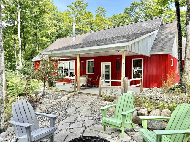 2144 N Jacobson Rd, Suttons Bay, MI 49682 - rear view of property featuring a shingled roof, a patio, and board and batten siding