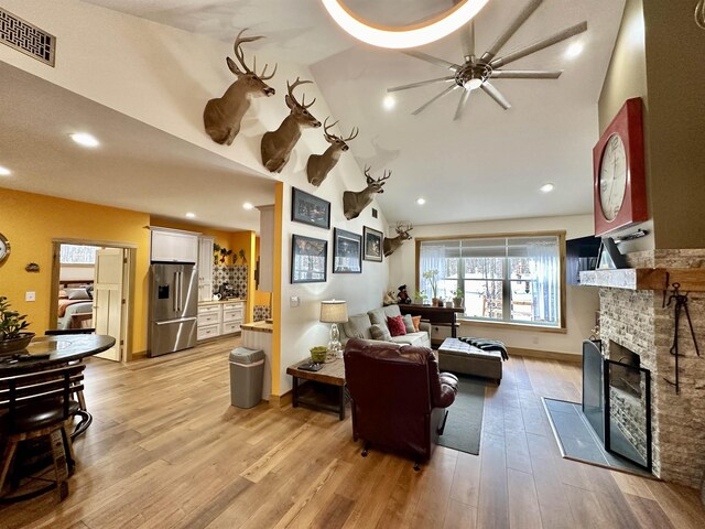 2144 N Jacobson Rd, Suttons Bay, MI 49682 - living area featuring a ceiling fan, a fireplace, light wood finished floors, recessed lighting, and vaulted ceiling