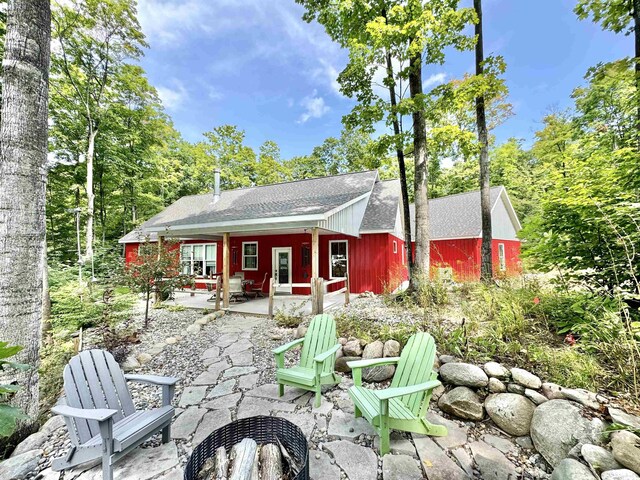2144 N Jacobson Rd, Suttons Bay, MI 49682 - ranch-style house with asphalt driveway, a garage, a front yard, and a shingled roof
