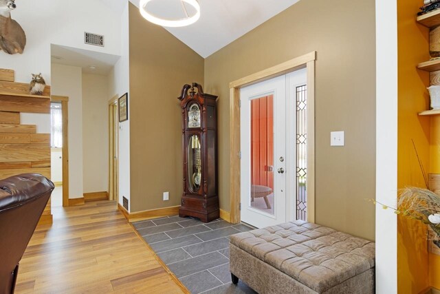 2144 N Jacobson Rd, Suttons Bay, MI 49682 - foyer with dark wood-type flooring, stairs, baseboards, and high vaulted ceiling