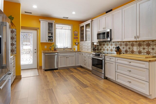 2144 N Jacobson Rd, Suttons Bay, MI 49682 - kitchen with stainless steel appliances, a sink, backsplash, light wood-style floors, and recessed lighting