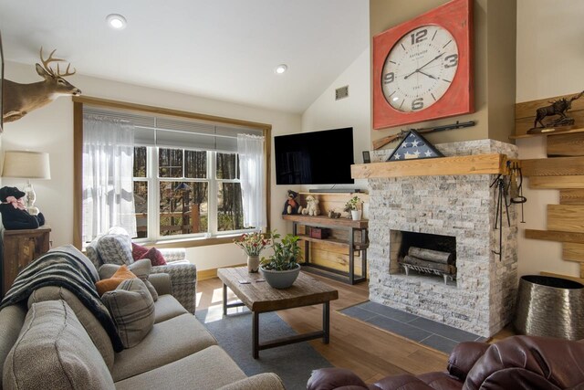 2144 N Jacobson Rd, Suttons Bay, MI 49682 - living room with a stone fireplace, vaulted ceiling, wood finished floors, and recessed lighting