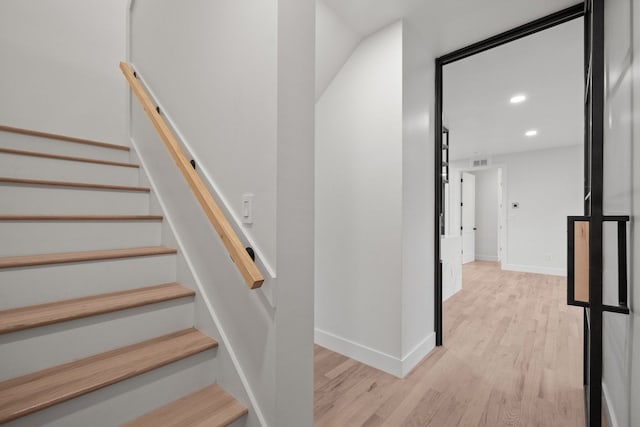 stairway with hardwood / wood-style floors