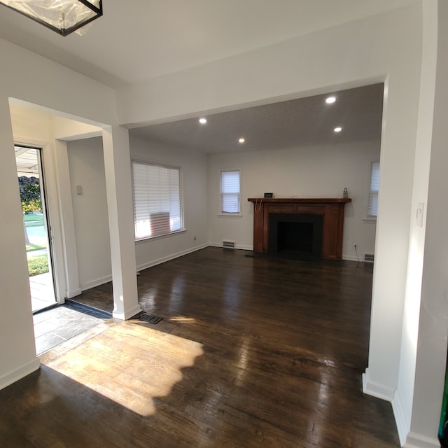 unfurnished living room featuring dark wood-type flooring