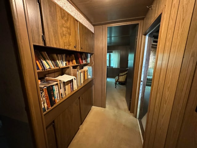 corridor with wooden walls and light colored carpet