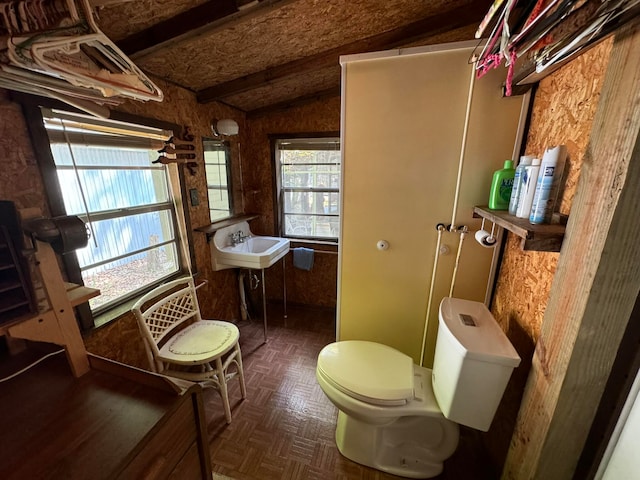 bathroom with vaulted ceiling with beams, toilet, parquet floors, and sink