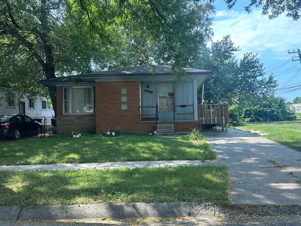 8949 Lauder St, Detroit, MI 48228 - view of front facade with a front lawn, covered porch, and brick siding