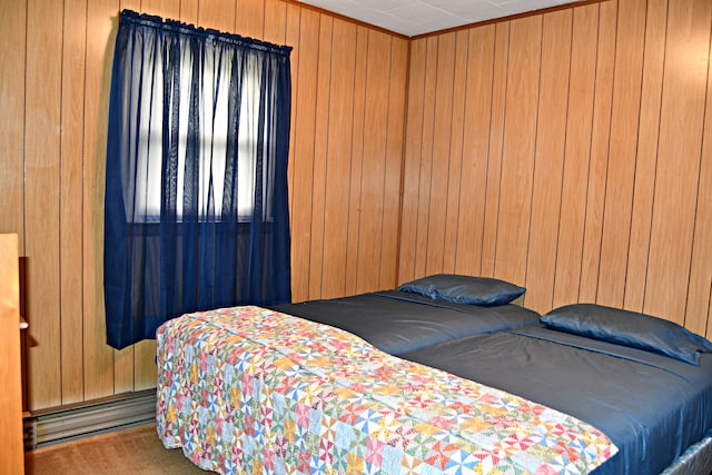 bedroom with baseboard heating and wooden walls