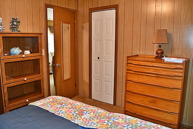 bedroom featuring a closet and wooden walls