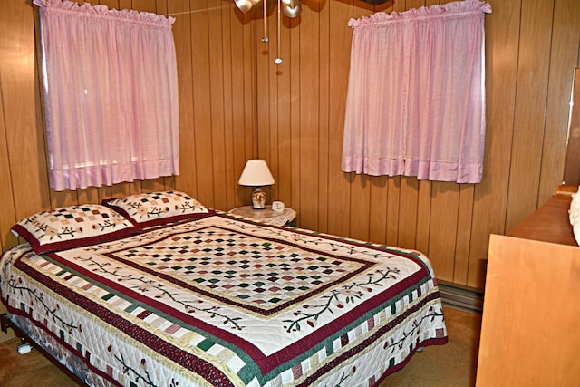 bedroom featuring carpet floors and wood walls