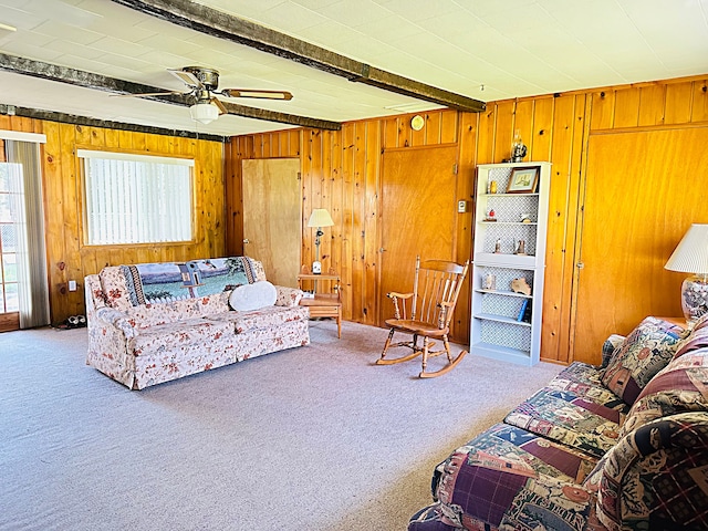 living room with beamed ceiling, carpet floors, and ceiling fan