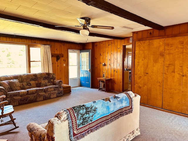 living room with wood walls, a healthy amount of sunlight, and light colored carpet