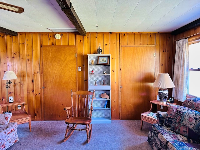 living area featuring carpet flooring and wooden walls