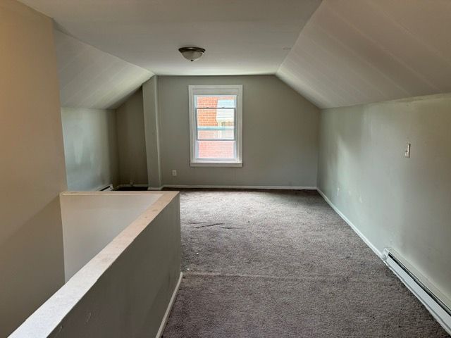 bonus room featuring carpet flooring, a baseboard radiator, and vaulted ceiling