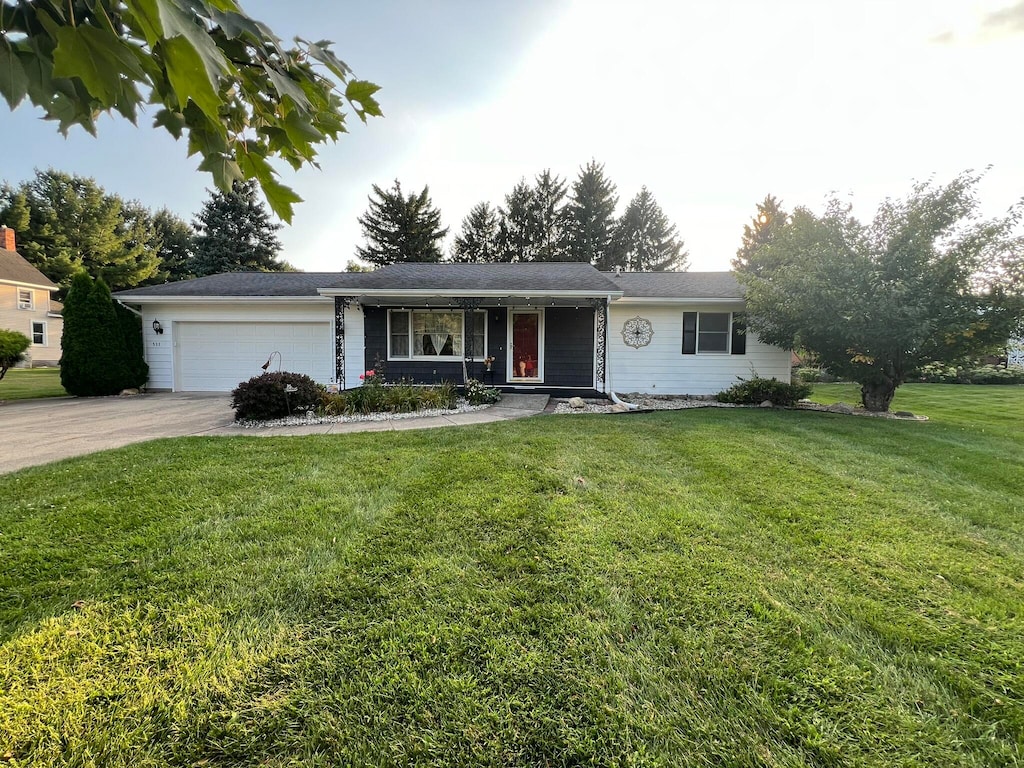 ranch-style home with a garage and a front lawn