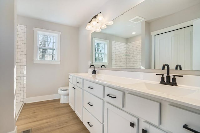 bathroom featuring hardwood / wood-style floors, toilet, vanity, and a healthy amount of sunlight