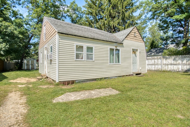 view of home's exterior featuring a lawn and a storage shed