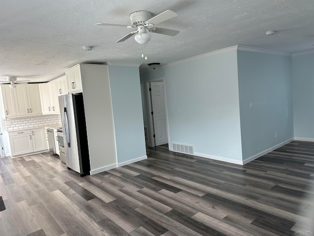 kitchen with dark hardwood / wood-style floors, backsplash, stainless steel fridge, white cabinets, and ornamental molding