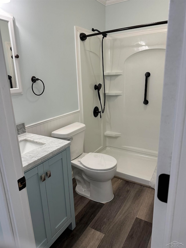 bathroom featuring a shower, wood-type flooring, vanity, and toilet