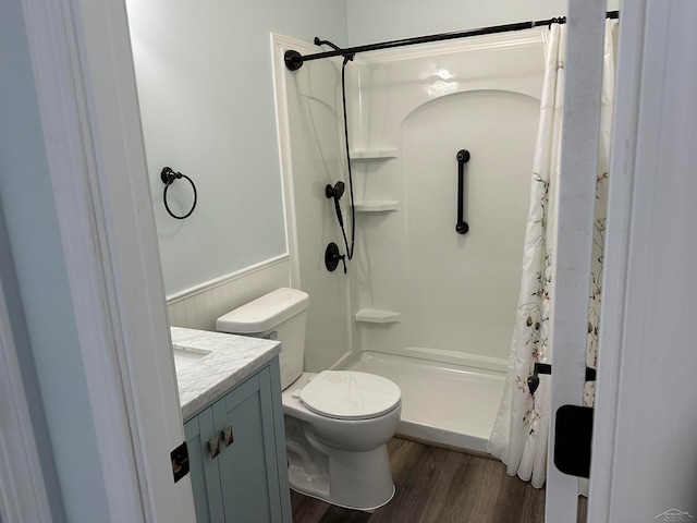 bathroom with hardwood / wood-style floors, vanity, toilet, and walk in shower