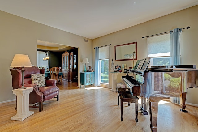 sitting room with light hardwood / wood-style floors and an inviting chandelier