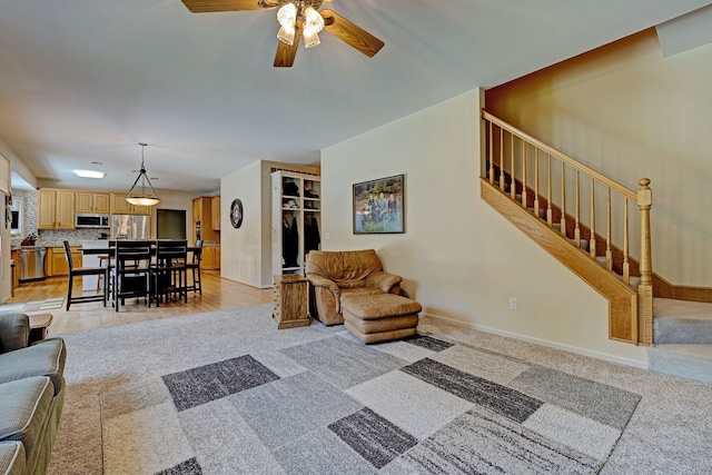 carpeted living room with ceiling fan