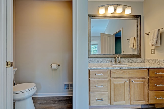 bathroom featuring hardwood / wood-style flooring, vanity, and toilet