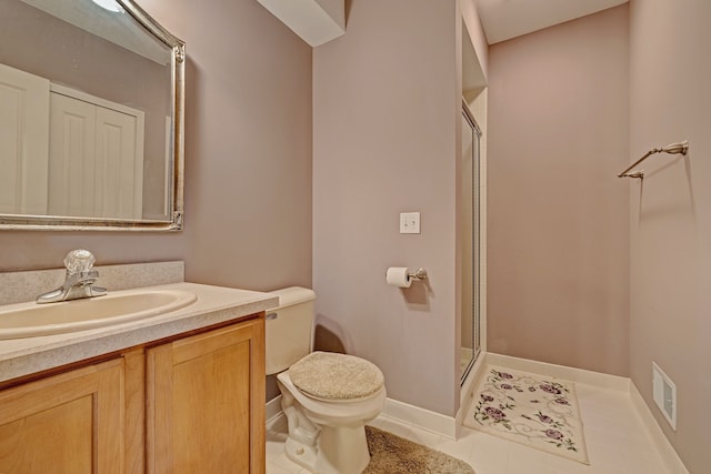 bathroom featuring tile patterned flooring, vanity, an enclosed shower, and toilet